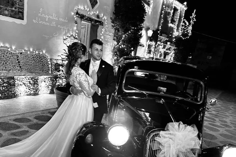 Sposi accanto all'auto d'epoca, bianco e nero