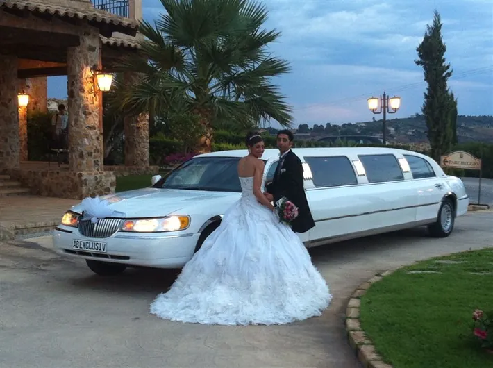 La limousine Lincoln bianca con gli sposi davanti a una villa