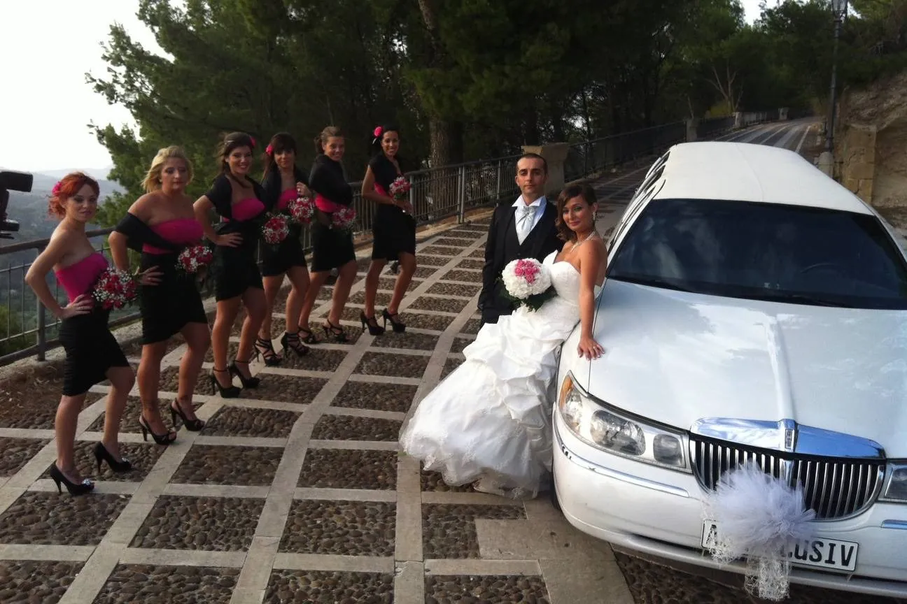Limousine Lincoln bianca con la sposa e le damigelle in rosa